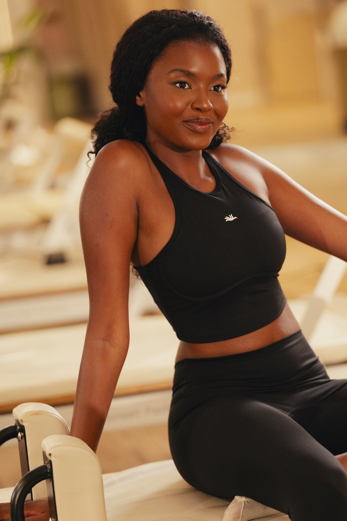 The Reformer Set in Black: Pulse Bra, high-neck racer, on the reformer